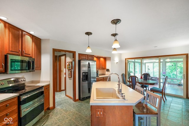2508 Indian Creek Rd, Trafalgar, IN 46181 - kitchen with stainless steel appliances, a sink, light countertops, brown cabinetry, and hanging light fixtures