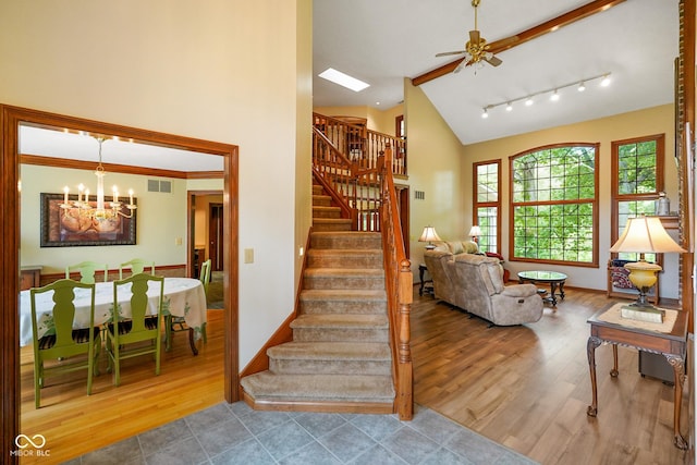 2508 Indian Creek Rd, Trafalgar, IN 46181 - staircase featuring wood finished floors, a chandelier, ceiling fan, baseboards, and high vaulted ceiling