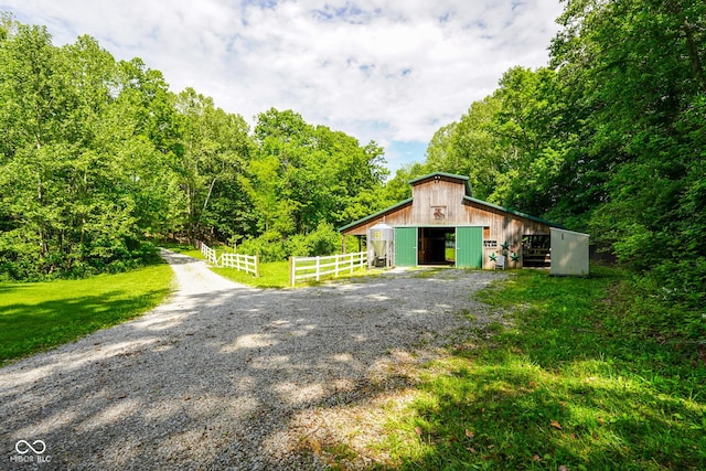 2508 Indian Creek Rd, Trafalgar, IN 46181 - garage with gravel driveway and a forest view