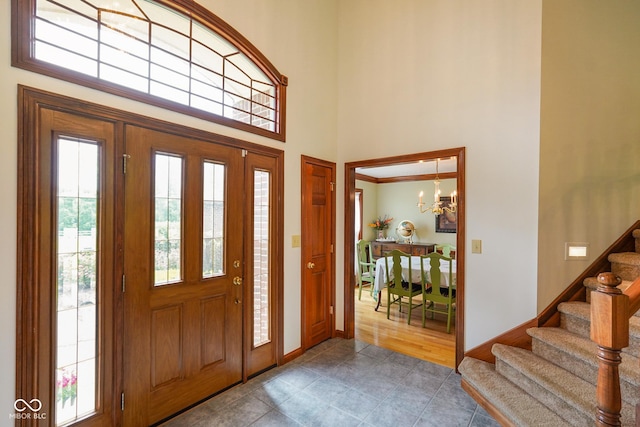 2508 Indian Creek Rd, Trafalgar, IN 46181 - entryway featuring stairs, a chandelier, a high ceiling, tile patterned flooring, and baseboards