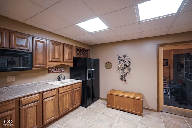2508 Indian Creek Rd, Trafalgar, IN 46181 - kitchen featuring black appliances, a sink, a drop ceiling, light tile patterned floors, and brown cabinets