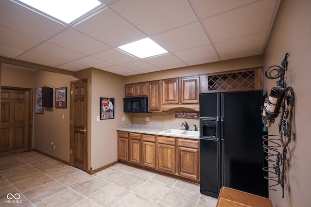 2508 Indian Creek Rd, Trafalgar, IN 46181 - kitchen with black appliances, a sink, light tile patterned floors, light countertops, and brown cabinetry