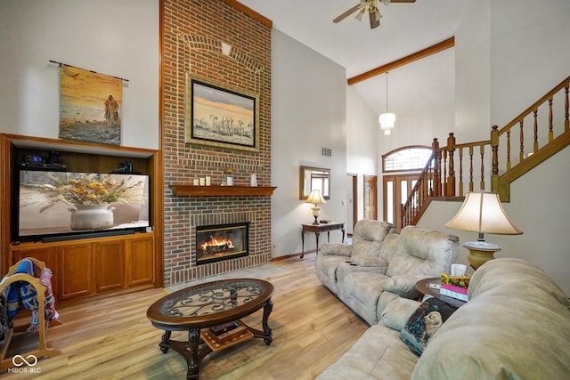 2508 Indian Creek Rd, Trafalgar, IN 46181 - living area with high vaulted ceiling, light wood-style flooring, a ceiling fan, stairway, and a brick fireplace
