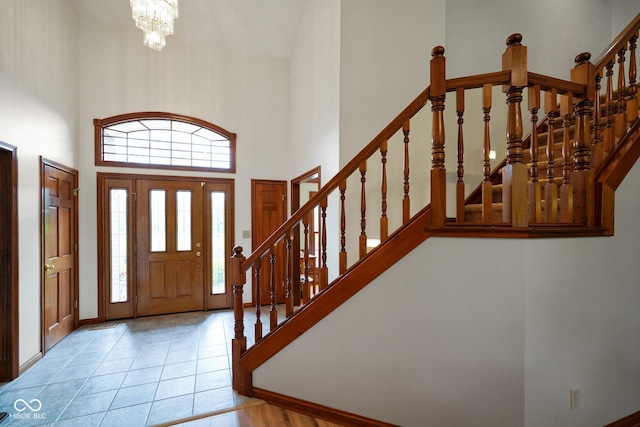 2508 Indian Creek Rd, Trafalgar, IN 46181 - foyer featuring a high ceiling, stairway, a chandelier, light tile patterned floors, and baseboards
