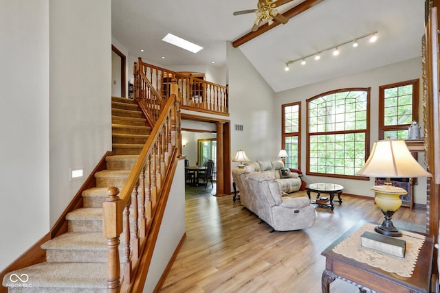 2508 Indian Creek Rd, Trafalgar, IN 46181 - living room with light wood-type flooring, stairs, a ceiling fan, baseboards, and high vaulted ceiling