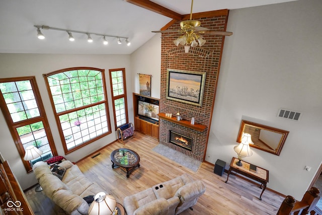 2508 Indian Creek Rd, Trafalgar, IN 46181 - living room with a fireplace, a ceiling fan, light wood-style floors, rail lighting, and baseboards