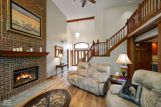 2508 Indian Creek Rd, Trafalgar, IN 46181 - living area featuring a high ceiling, wood finished floors, ceiling fan, a fireplace, and stairway