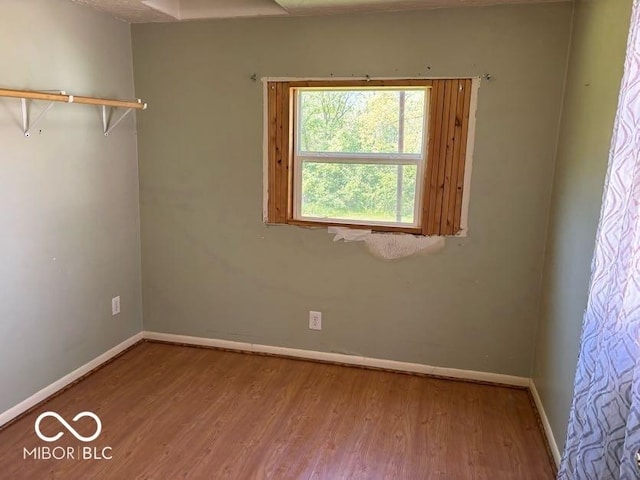 spare room featuring wood finished floors and baseboards