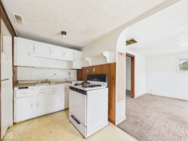 29 E Pine St, Anderson, IN 46012 - kitchen featuring white range with gas cooktop, white cabinetry, light countertops, a sink, and arched walkways