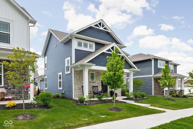 2542 Barstow Dr, Whitestown, IN 46075 - craftsman-style home with stone siding, a front lawn, and a porch