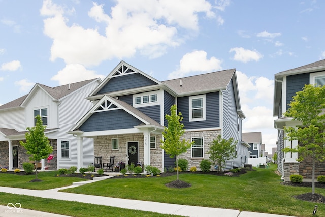2542 Barstow Dr, Whitestown, IN 46075 - view of front of home featuring stone siding, a front yard, a porch, and roof with shingles
