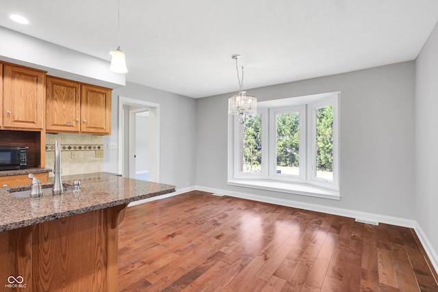 10602 Fall Rd, Fishers, IN 46037 - kitchen featuring baseboards, tasteful backsplash, stone countertops, pendant lighting, and recessed lighting