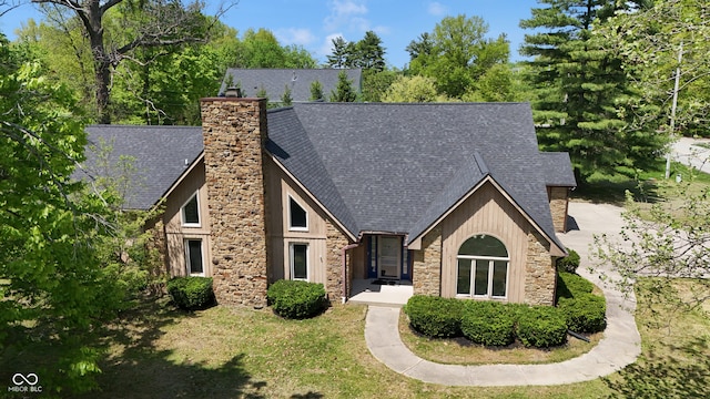10602 Fall Rd, Fishers, IN 46037 - view of front of home featuring stone siding, a chimney, roof with shingles, and a front yard