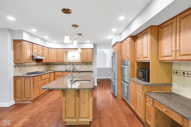 10602 Fall Rd, Fishers, IN 46037 - kitchen featuring a sink, stainless steel appliances, backsplash, dark stone countertops, and a center island with sink