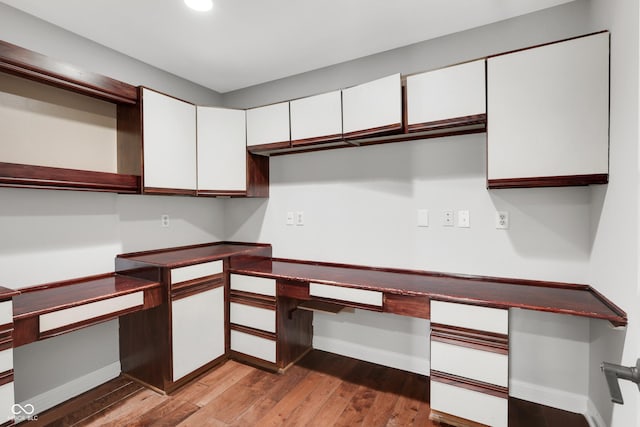 10602 Fall Rd, Fishers, IN 46037 - unfurnished office featuring baseboards, built in desk, wood finished floors, and recessed lighting