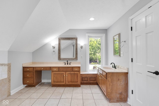 10602 Fall Rd, Fishers, IN 46037 - bathroom with lofted ceiling, two vanities, tile patterned floors, a tub, and a textured ceiling