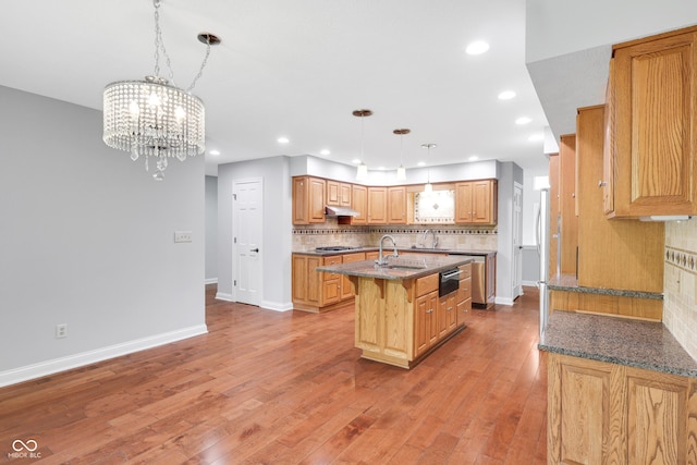 10602 Fall Rd, Fishers, IN 46037 - kitchen featuring a sink, a kitchen island with sink, tasteful backsplash, under cabinet range hood, and stainless steel gas stovetop