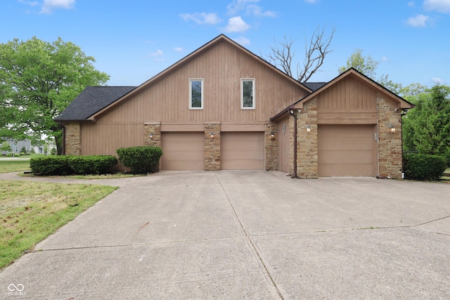 10602 Fall Rd, Fishers, IN 46037 - view of front of house featuring stone siding, roof with shingles, concrete driveway, and a garage