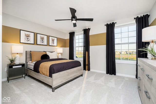 bedroom featuring baseboards, light carpet, and a ceiling fan