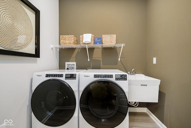 laundry area featuring separate washer and dryer, wood finished floors, and baseboards