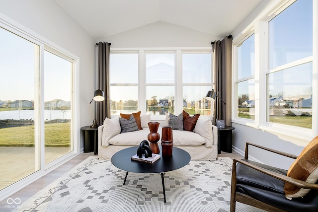 sunroom featuring lofted ceiling and a water view