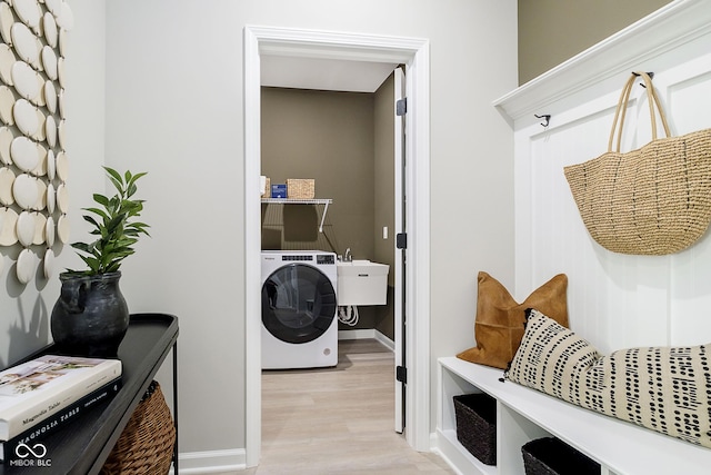 mudroom with washer / clothes dryer, light wood-type flooring, baseboards, and a sink