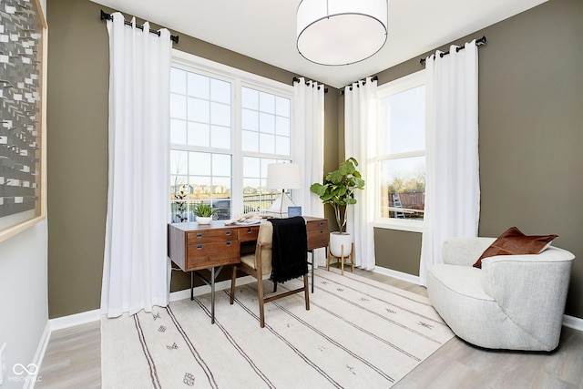 home office featuring healthy amount of natural light, light wood finished floors, and baseboards