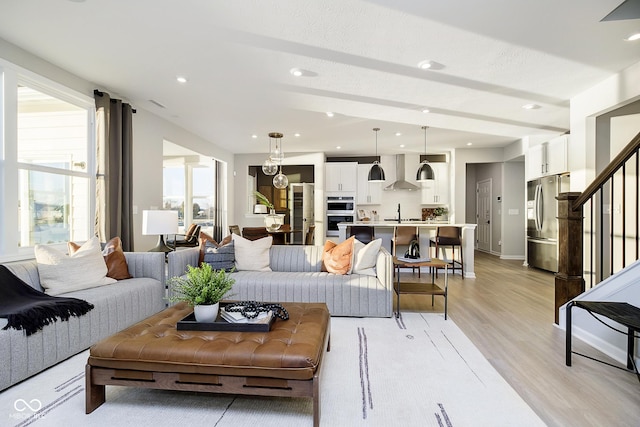 living area with light wood-style flooring, recessed lighting, stairs, and baseboards