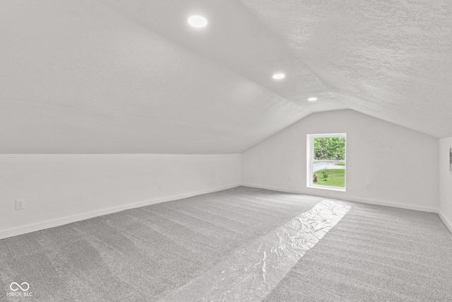 2321 W 26th St, Anderson, IN 46016 - additional living space with vaulted ceiling, carpet flooring, baseboards, a textured ceiling, and recessed lighting