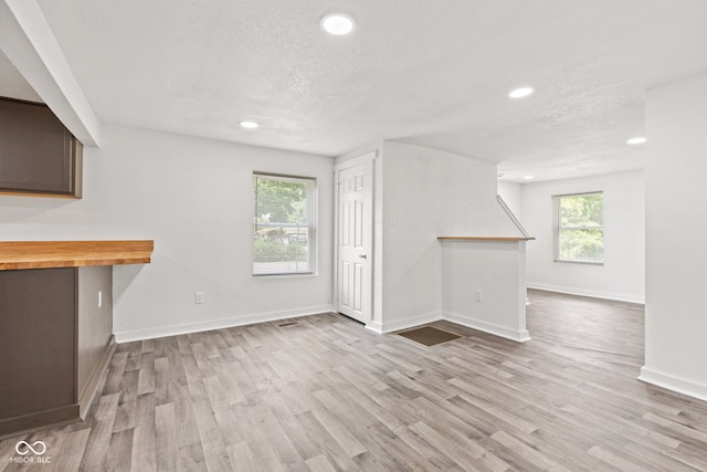 2321 W 26th St, Anderson, IN 46016 - unfurnished living room featuring recessed lighting, wood finished floors, baseboards, and a textured ceiling