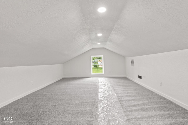 2321 W 26th St, Anderson, IN 46016 - bonus room featuring a textured ceiling, carpet, vaulted ceiling, baseboards, and recessed lighting