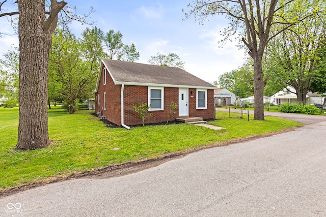 2321 W 26th St, Anderson, IN 46016 - view of front facade with brick siding, a front yard, and roof with shingles