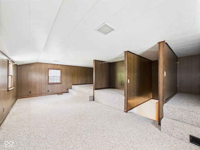 basement featuring wood walls and light carpet