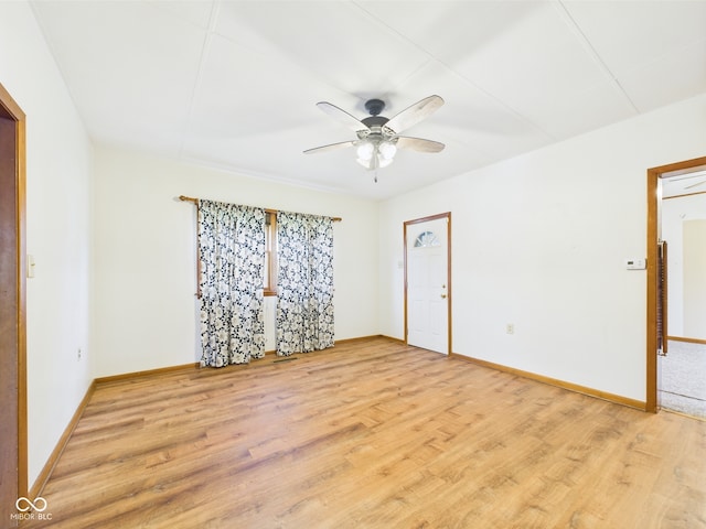 unfurnished room with light wood-type flooring, a ceiling fan, and baseboards
