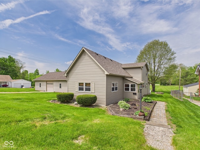 back of property with roof with shingles and a detached garage