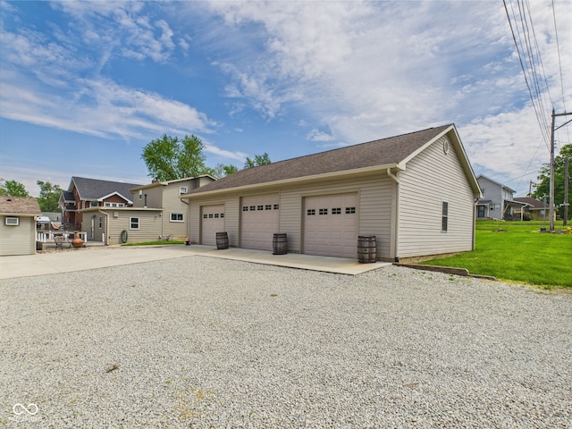 view of front of house with driveway, a garage, a front yard, a residential view, and an outbuilding
