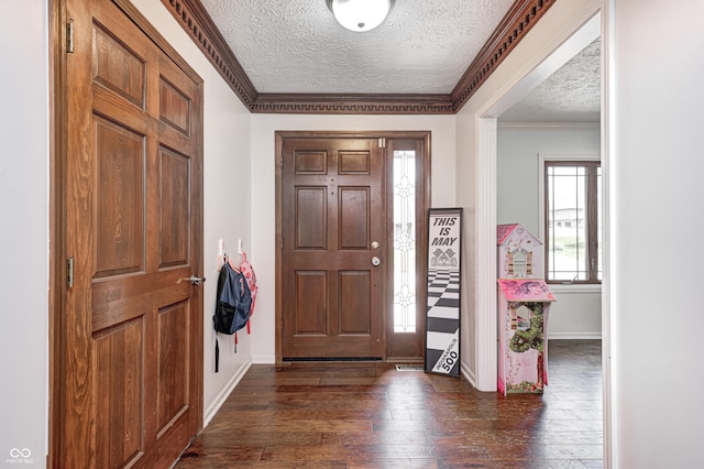 entrance foyer with a textured ceiling, dark wood-style floors, ornamental molding, and baseboards
