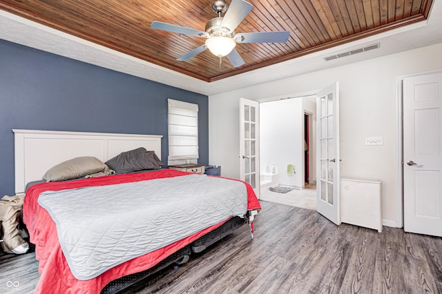 bedroom with a raised ceiling, french doors, wooden ceiling, and wood finished floors