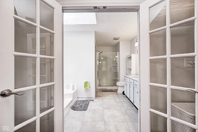 full bath with a shower stall, toilet, vanity, a garden tub, and tile patterned floors