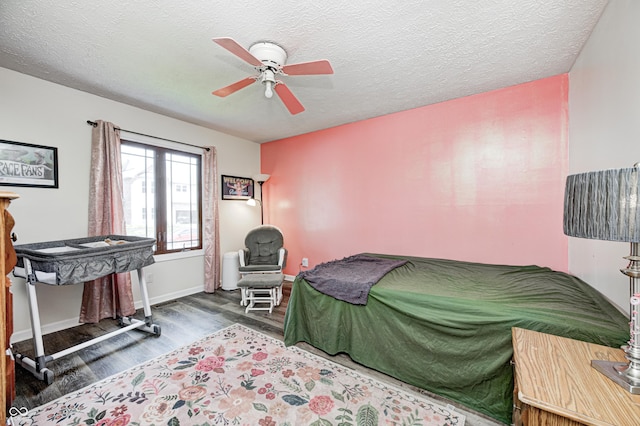 bedroom with wood finished floors, a ceiling fan, baseboards, and a textured ceiling