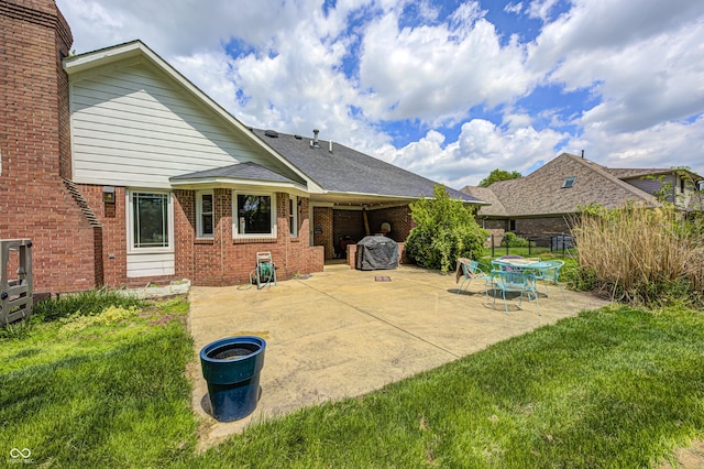 back of property with a patio and brick siding
