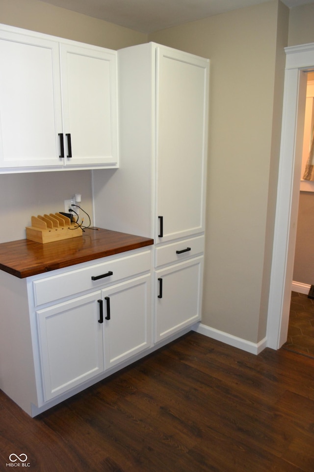 bar featuring dark wood-style flooring and baseboards