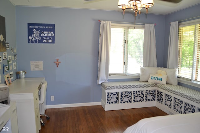 bedroom featuring wood finished floors, multiple windows, baseboards, and a chandelier