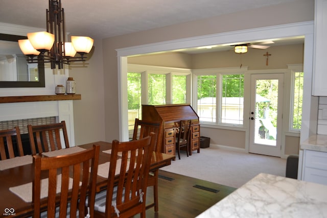 dining room featuring a chandelier, ceiling fan, and baseboards
