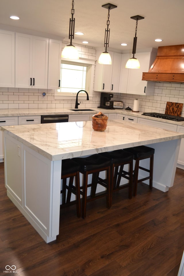 kitchen with custom range hood, a sink, a kitchen island, black gas stovetop, and recessed lighting