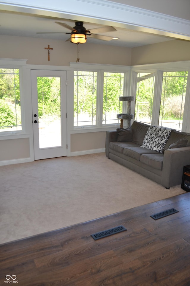 living area with ceiling fan and baseboards