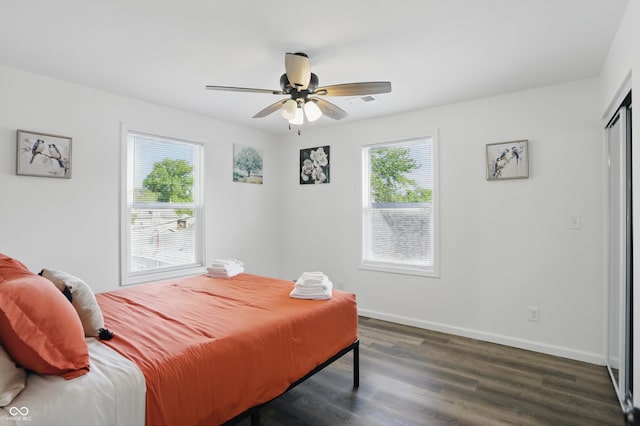 bedroom with dark wood-style floors, baseboards, and a ceiling fan