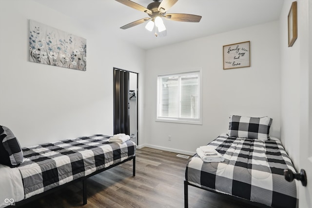 bedroom with wood finished floors, baseboards, and a ceiling fan