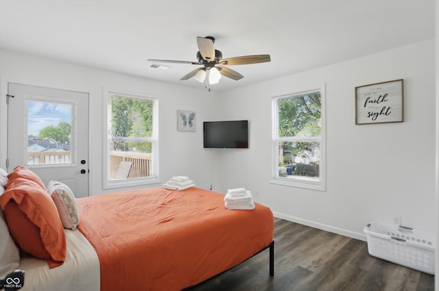 bedroom featuring multiple windows, dark wood-style floors, ceiling fan, and baseboards