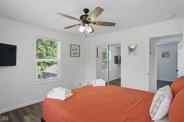 bedroom featuring dark wood-type flooring, baseboards, a closet, and a ceiling fan